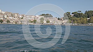 Kayak pov view city skyline of ancient village of Anguillara Sabazia in Italy