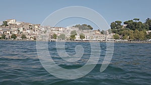 Kayak pov view city skyline of beautiful and picturesque village of Anguillara Sabazia located on the shores of Bracciano lake