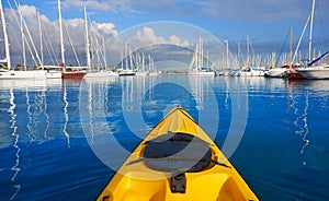 Kayak sailing in a marina port with boats