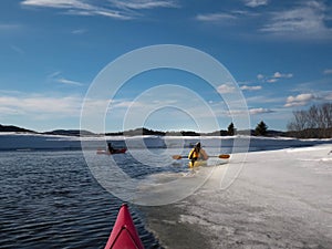 Kayak surfers in action  on an icy lake