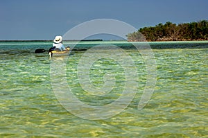 A kayaker floating in turquoise green waters in the Florida Keys