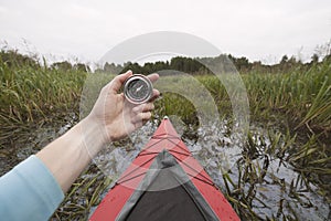 Kayaker lost way and holding compass.