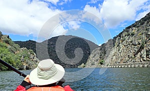 kayaker in orange vest and river and hills