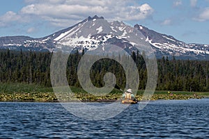 Kayaker paddling on beautiful mountain lake near Bend, Oregon