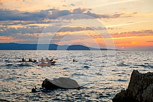 Kayaker paddling the kayak at sunset sea. Kayaking, canoe, paddling. Amazing beach sunset with endless horizon and