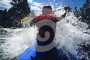 Kayaker Paddling Through Rapids