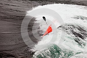 Kayaker in white water paddling breaking waves