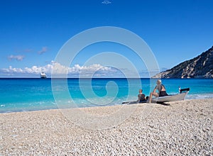 Kayakers on the kayak and a beautiful yacht in the background of clouds on the island of Kefalonia in the Ionian Sea in Greece