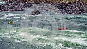Kayakers navigating through the White Water Rapids and around Rocks