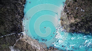 Kayakers paddling on river Soca on a Winter day. Top Down Drone Photo.