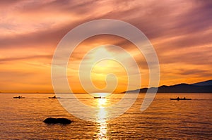 Kayakers Silhouette On Ocean During Orange Sunset