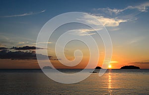 Kayakers silhouette on ocean during sunset