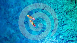 Kayaking. Aerial view of floating kayaks and people on blue sea at sunny day. Travel and active life image.