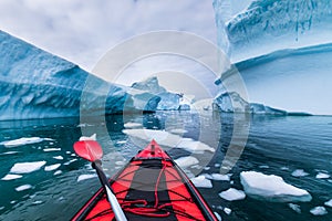 Kayaking in Antarctica between icebergs with inflatable kayak, extreme adventure in Antarctic Peninsula , beautiful pristine