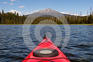 Kayaking beautiful lake in summer toward mountain peak