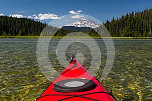 Kayaking beautiful lake in summer toward mountain peak