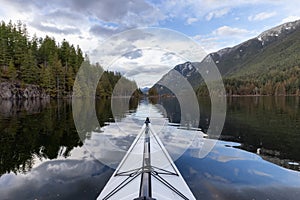 Kayaking in calm water with Canadian Mountain Landscape Background.