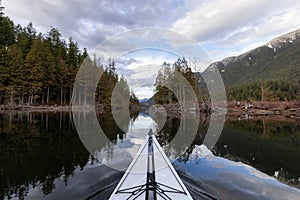 Kayaking in calm water with Canadian Mountain Landscape Background.