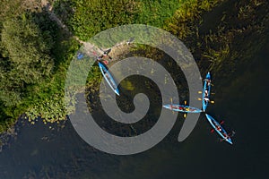 Kayaking and canoeing in the summer river. Aerial drone view on kayaks and river bank