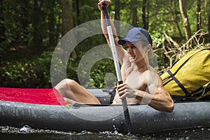 Kayaking and canoeing. Young man with oar swim in kayak. Athletic man in boat with oars are swimming on river. tourist in canoe