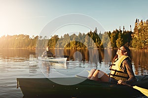 Kayaking is cheaper than therapy. a young couple kayaking on a lake outdoors.