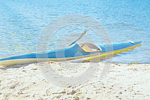 Kayaking concept.Kayak on the beach. Kayak blue and yellow. Boat on the river bank. Summer sunny day.