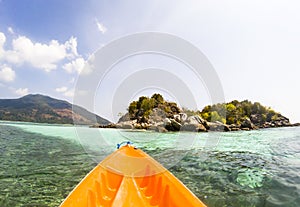 kayaking in crystal clear tropical waters - kayak heading to isolated beach in Ko Tarutao national park