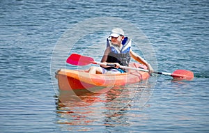 Kayaking lessons. Boy with life buoy suit in kayak lessons during summer vacations in an island of Greece