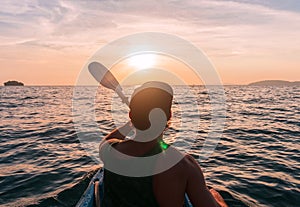 Kayaking. Man With kayak paddle at sunset sea Rowing to the Sun.