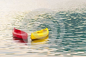 Kayaking. Red and yellow kayaks on open sea waves in sunset light. Right Side Copy Space. Water Sports and Summer Recreations