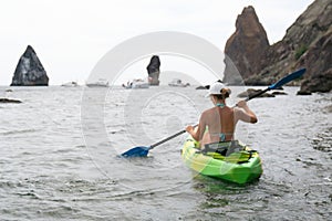 Woman kayak sea. Happy tourist enjoy taking picture outdoors for memories. Woman traveler posing in kayak canoe at sea