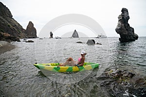 Woman kayak sea. Happy tourist enjoy taking picture outdoors for memories. Woman traveler posing in kayak canoe at sea