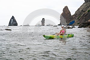 Woman kayak sea. Happy tourist enjoy taking picture outdoors for memories. Woman traveler posing in kayak canoe at sea