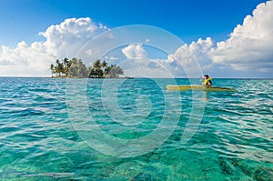 Kayaking in tropical paradise - Canoe floating on transparent turquoise water, caribbean sea, Belize, Cayes islands photo