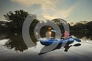 Kayaking water sports with copy space. Young Kayaker man in a beautiful lake during sunrise in the morning