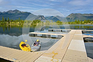 Kayaks floating on a mountain lake at a dock during the day