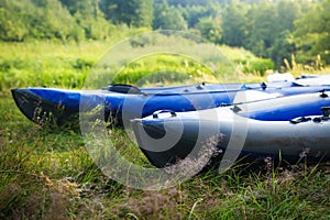 Kayaks on the grass on the river bank. Boats or canoes.