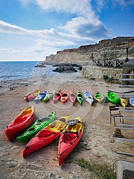 Kayaks lie on the shore near the sea without people