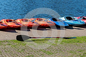 Kayaks lined up on a the bank of a lake