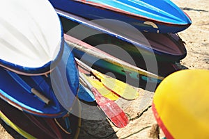 Kayaks on sand beach. Colorful boats in front of sea coast.