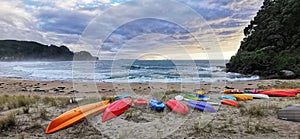 Kayaks scattered on a sandy dune at Onemana beach, Coromandel, New Zealand