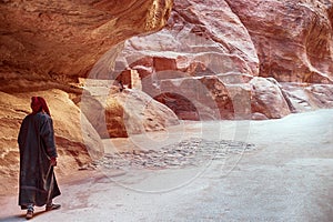 Kayon Sik. Bewin, dressed in traditional clothing, walks along the canyon wall. Petra Jordan