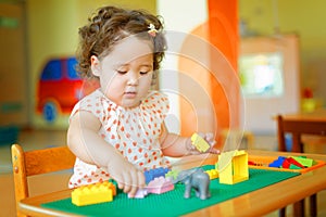 Kazakh curly girl playing in kids development center