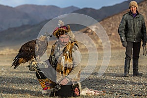 Kazakh Eagle Hunter traditional clothing, while hunting to the hare holding a golden eagle on his arm