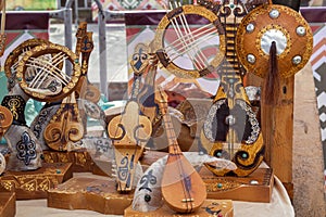 Kazakh national handmade musical instruments with horsehair strings are sold on a street stall on a sunny day.