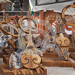 Kazakh national handmade musical instruments with horsehair strings are sold on a street stall on a sunny day.