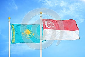 Kazakhstan and Singapore two flags on flagpoles and blue sky photo