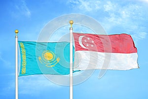 Kazakhstan and Singapore two flags on flagpoles and blue sky