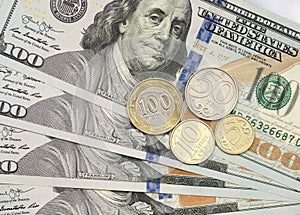 Kazakhstan tenge coin on top of dollar bills