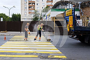 Kazan, Russia, June 2019: Workers make asphalt markings. Road workers draw a zebra - crosswalk